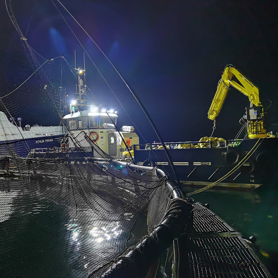 Voe Marine Vessel with crane at night on a sea farm